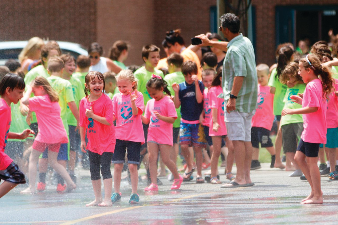 COOL CONCEPT: Students at Hoxsie School in Warwick enjoy running through water sprayed from a fire truck in this June 2018 photo. Cranston Ward 3 Councilman John Donegan has introduced a resolution calling on the city to explore the creation of a “splash pad” off Dyer Avenue.